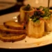 Roasted bone marrow in split beef bones served with toast and parsley salad on a plate