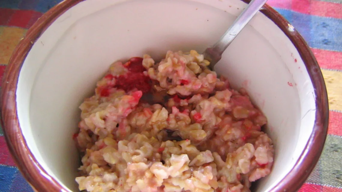 Bowl of creamy cooked oatmeal with visible oat flakes, showing how to cook oatmeal that stays loose